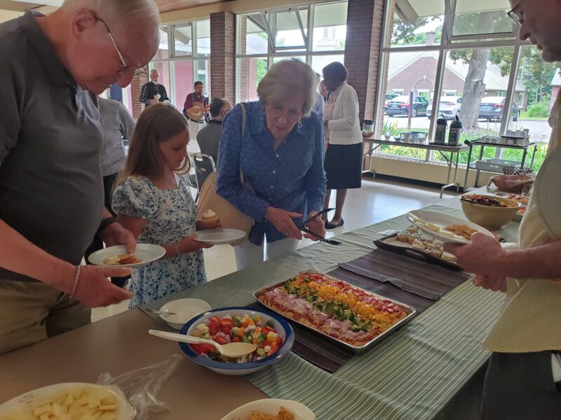 Smiling child and two adults at buffet of food