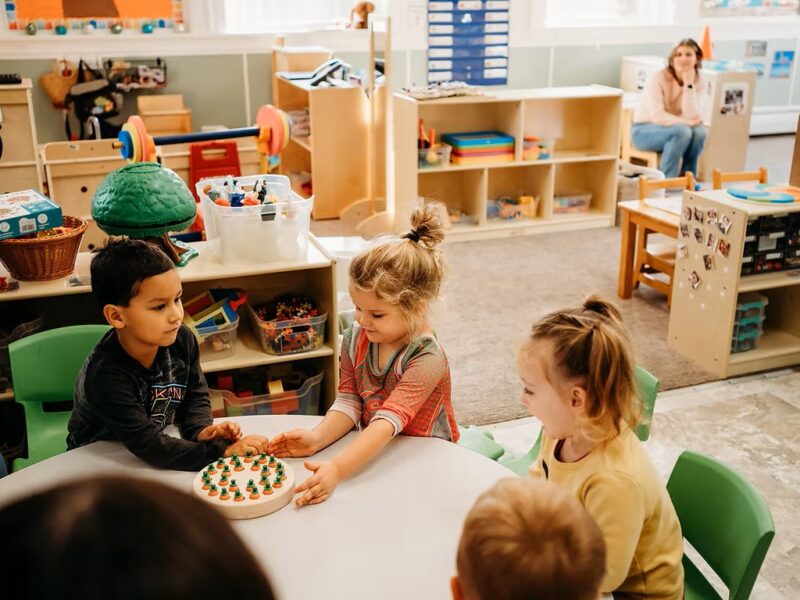 Group of children playing with toys around a table