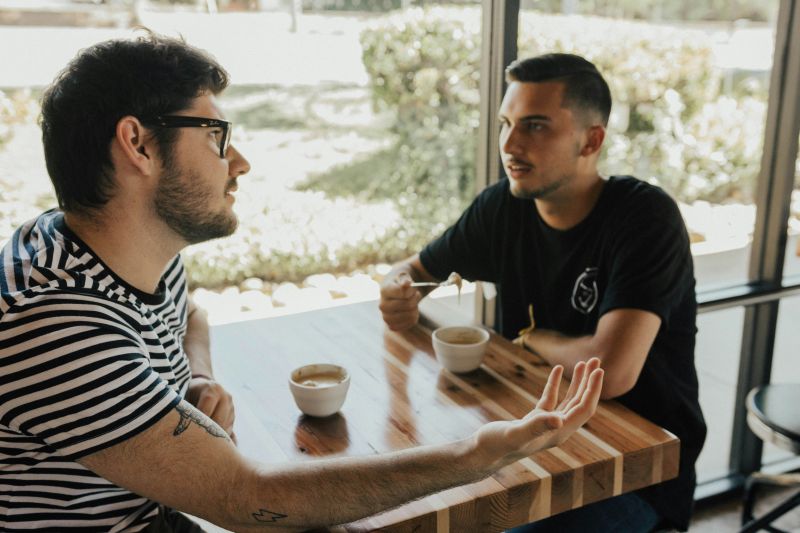 two men talking having coffee
