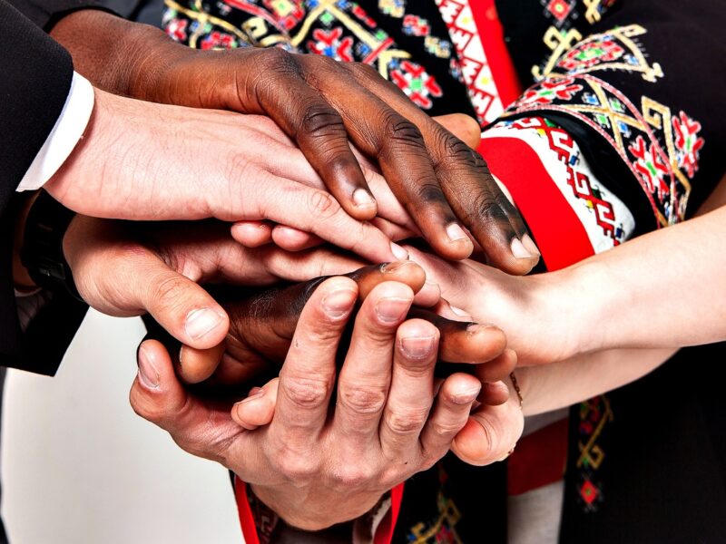 Multiracial hands clasping