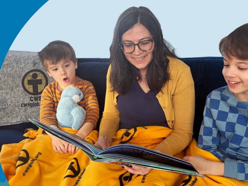 Woman reading to two children, with soft blanket on lap